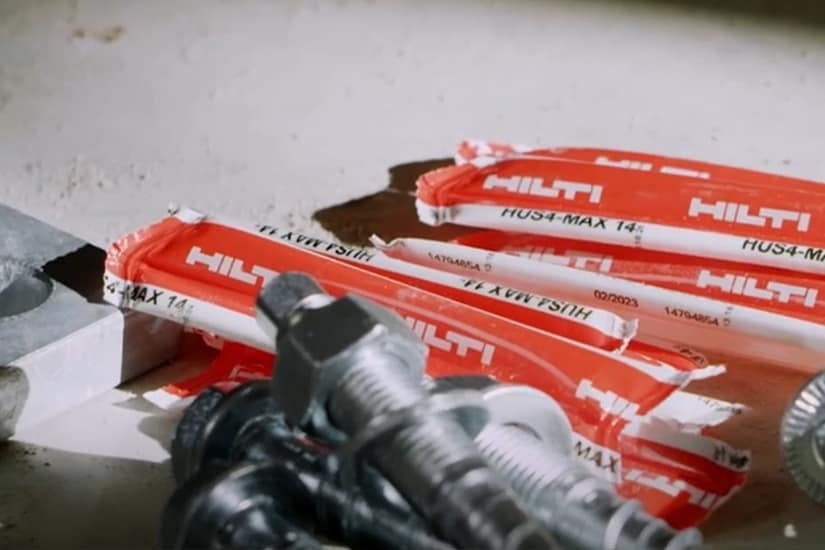 A worker attaches a formwork support with a concrete screw
