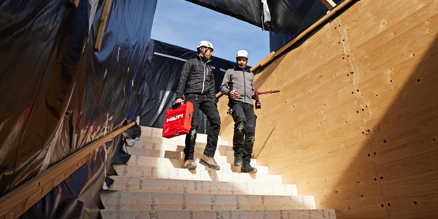 2 Arbeiter begutachten eine Holzbaukonstruktion