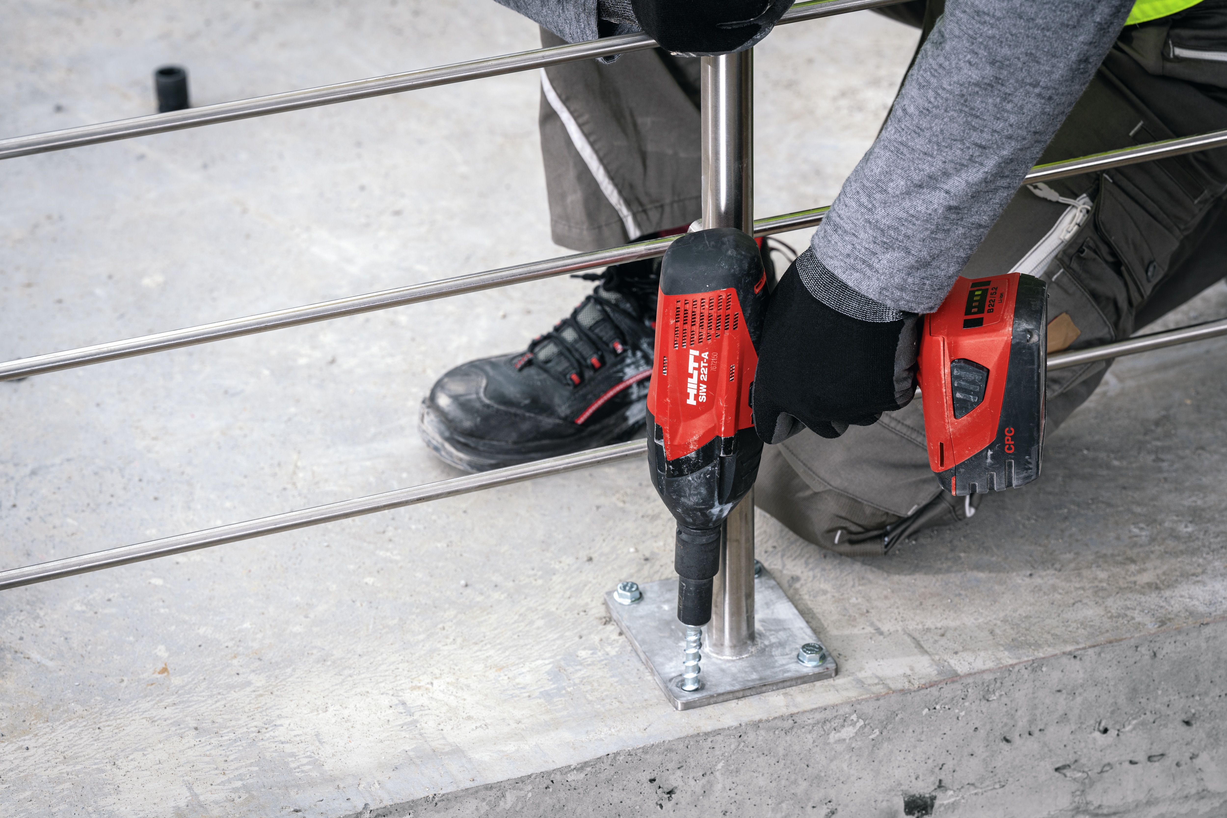 A worker attaches a formwork support with a concrete screw