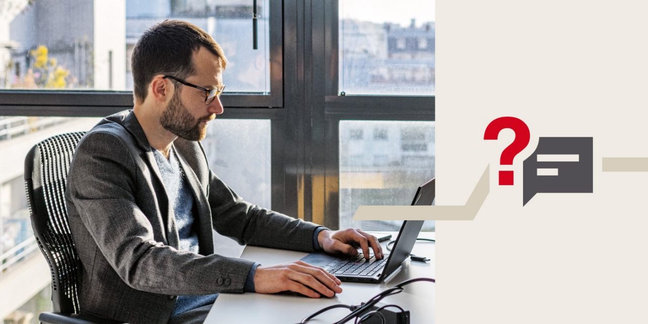 Ein Mann sitzt am Schreibtisch und arbeitet am Computer.