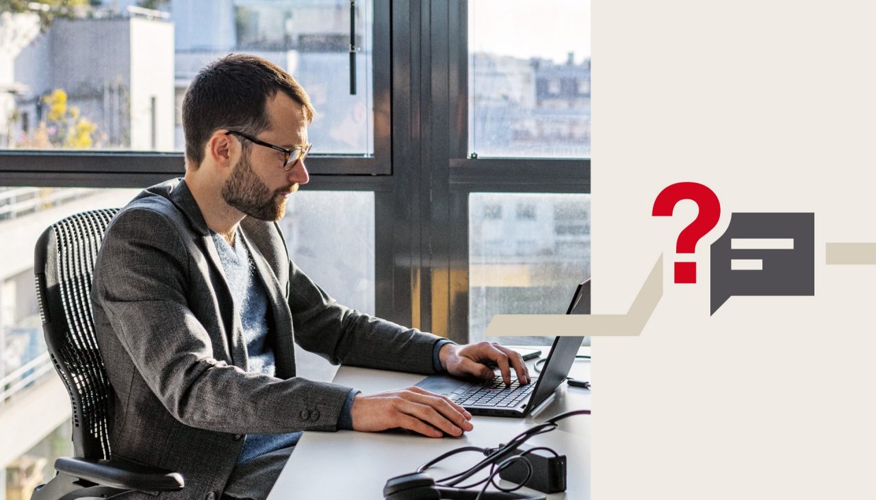Ein Mann mit Brille sitzt in einem Büro und arbeitet am Laptop.