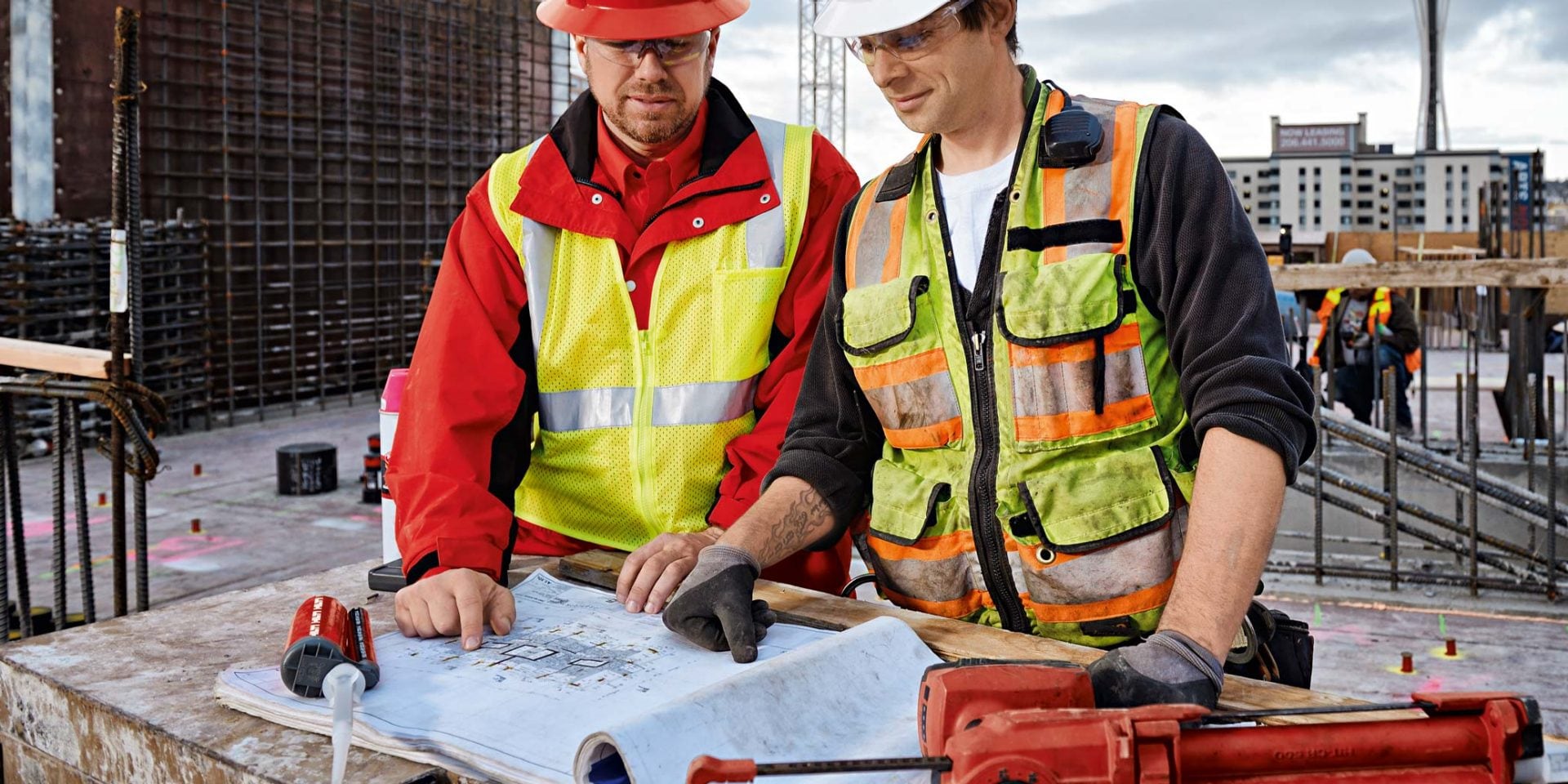 Bauleiter und Hilti Vertriebsberater auf der Baustelle mit Plan und Chemischen Dübeln