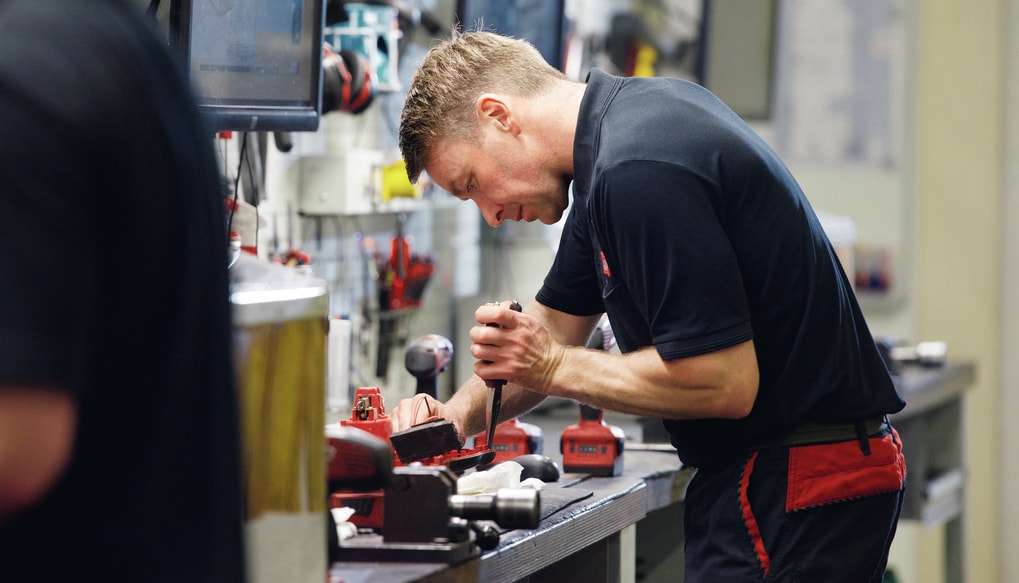 Arbeiter im Reparaturcenter schraubt an altem Gerät