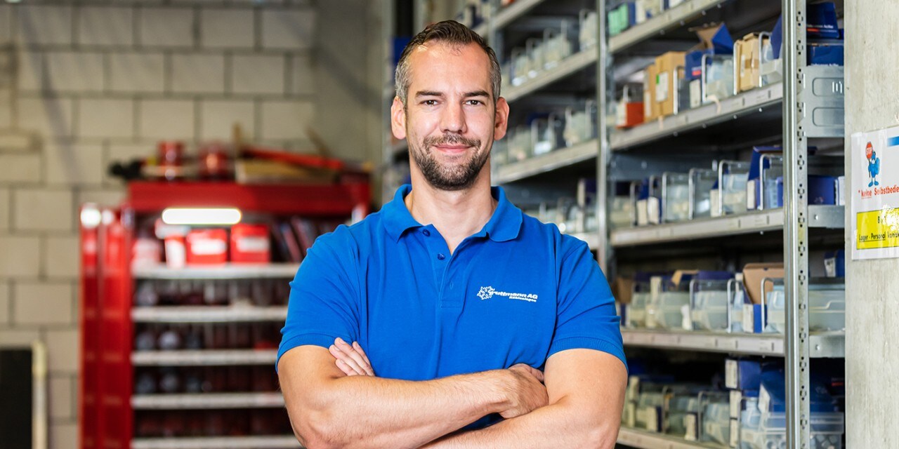 Ein Mitarbeiter der Truttmann AG steht mit verschränkten Armen in seinem Lager.
