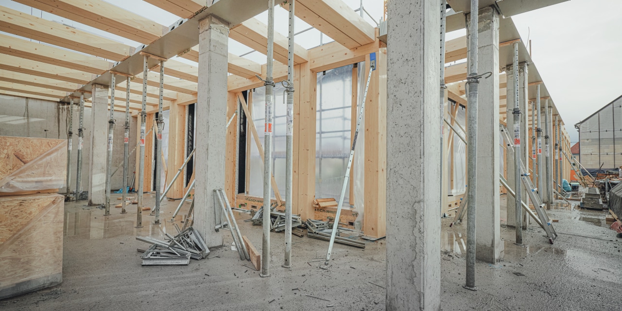 Fixations du bois sur béton – sur l’illustration, on voit des poteaux et des poutres en bois associés à des piliers en béton