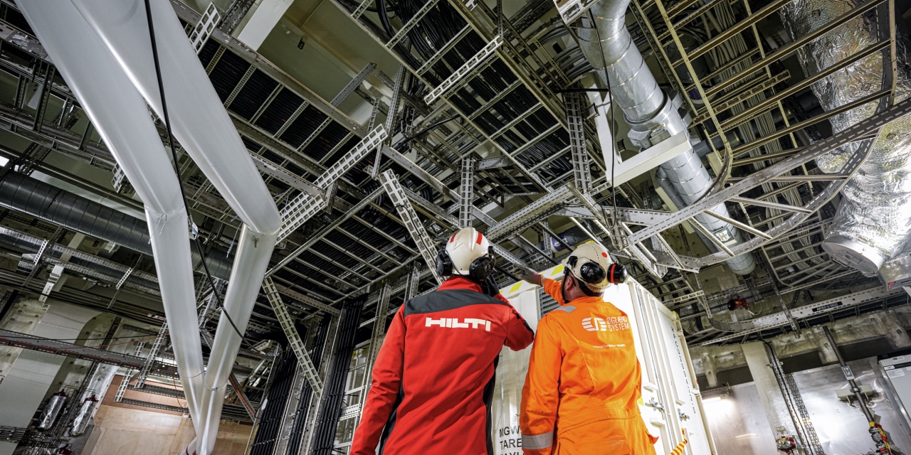 un employé Hilti et un client regardent une installation résistante à la corrosion