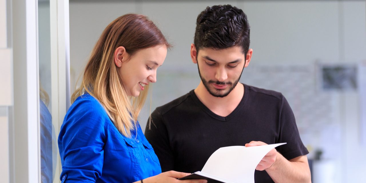 Zwei Junge Menschen schauen gemeinsam ein Papier an