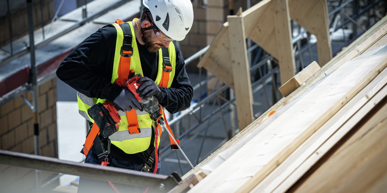 Ouvrier du bâtiment en train d'assembler du bois avec du bois
