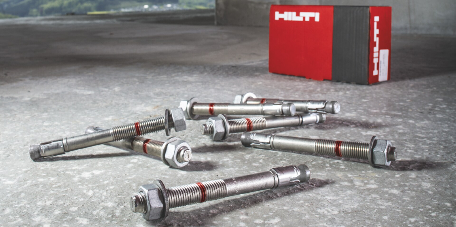 Diversi ancoraggi Hilti giacciono davanti a un pacco.