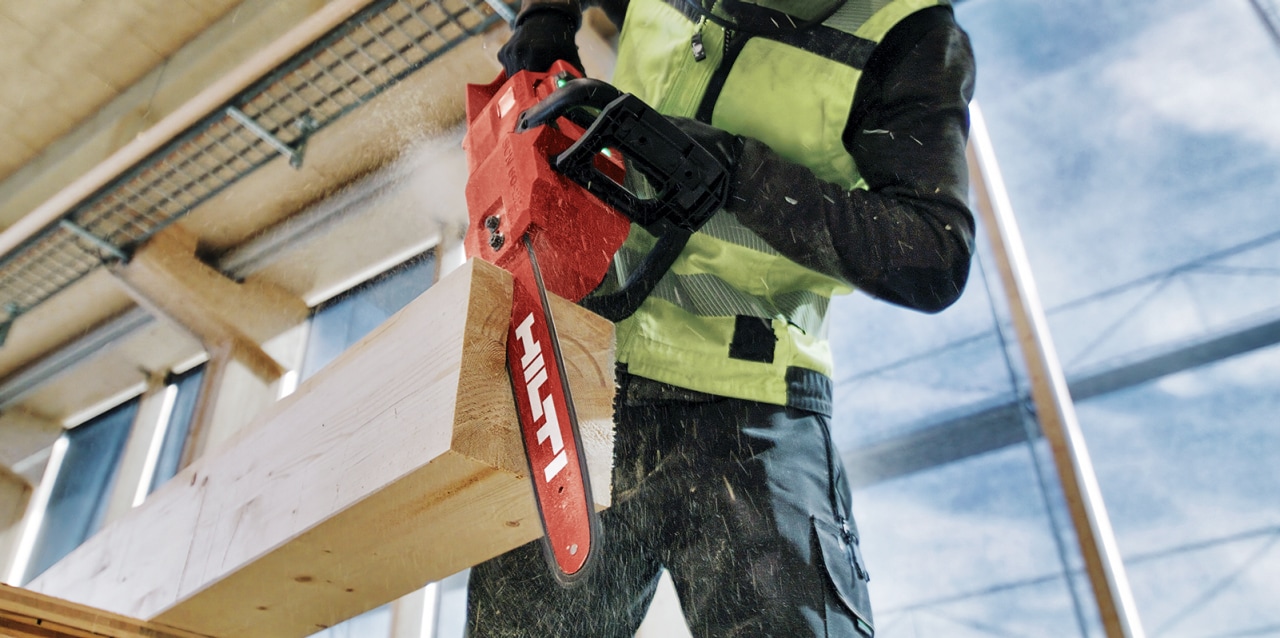 Operaio con motosega a batteria Hilti SCN 60-22 che sega una trave di legno